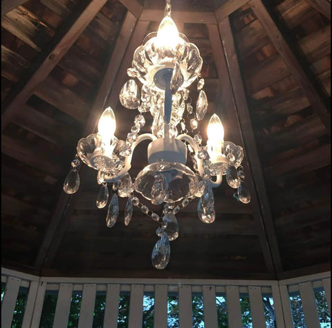 Plug In Crystal Swag Chandelier With Three Lights, White Metal Frame, Clear Glass Stem And Acrylic Crystals hanging in gazebo