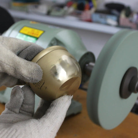 Hand holding polished brass item with Hella Durable 8 Inch Polyurethane Buffing Wheels 2000 Grit Silicon Carbide Abrasive in background.