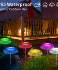Solar Jellyfish Garden Lights 6 Pack Waterproof Outdoor Pathway Lawn Decor With 7 Color Changing Optical Fiber Bodies glowing in rain.