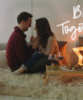 Couple in cozy setting with 'Better Together' neon sign, candles, and star decor, ideal for Pink You Are Like Really Pretty Neon Sign LED Wall Light