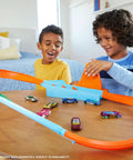 Kids playing with Rapid Raceway Champion Drag Race Track Set With Start Gate For Quick Countdown Side By Side One On One Racing Multi Car Launcher Connects To Other Sets Includes 1 64 Scale Car For Realistic Speed Play on a table.
