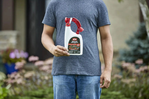 Person holding BugClear Insect Killer For Lawns And Landscapes Ready To Spray Kills 235 Bugs In Minutes 32 Oz bottle in garden
