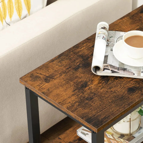 Rustic Brown And Black 3 Tier End Table With Open Storage Shelves holding a cup of coffee and rolled magazine on top surface.