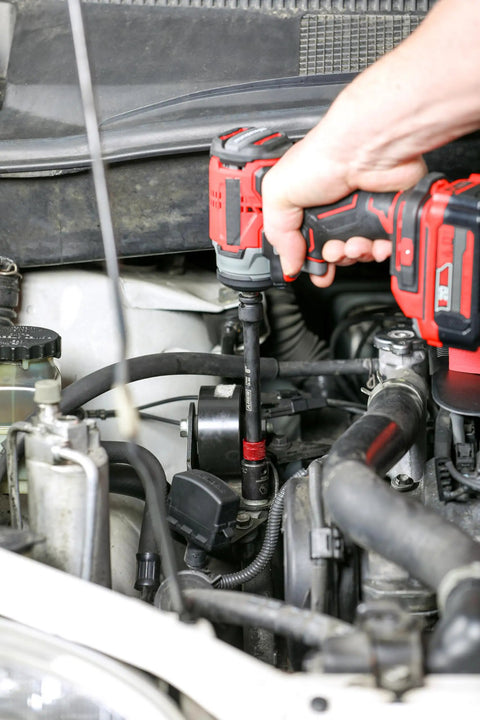 Using Long Reach Three Eighths Inch Drive Socket Extension Set on car engine for tight spaces with 12-inch extension.