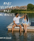 Two people sitting on a dock with a 16 Quart Portable Cooler That Keeps Ice Cold For Up To 36 Hours With TempLock Foam Insulation, Sapphire.