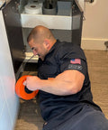 Person using Pro Grade Heavy Duty 25 Foot Steel Drum Auger Drain Snake Kit With One Quarter Inch Cable For One And A Quarter To Three Inch Drains under sink