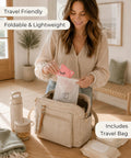 Woman unpacking a pink pouch from a foldable travel potty seat bag for toddlers featuring no pinch silicone grip.