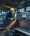 Worker using Beast Power 6 Inch 2000 Watt Brushless Angle Grinder for industrial cutting in a factory setting.