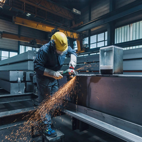 Worker using Beast Power 6 Inch 2000 Watt Brushless Angle Grinder for industrial cutting in a factory setting.