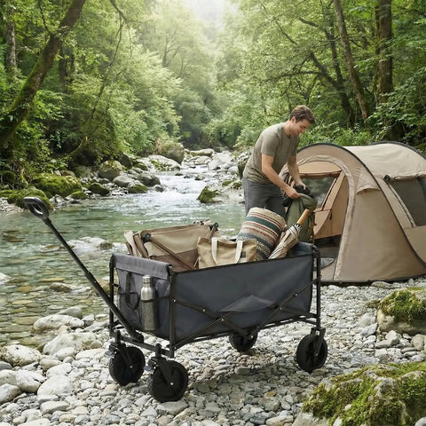 Collapsible Wagon Cart with Lockable Brakes by tent on rocky riverbank, carrying camping gear, gray, 330 lb capacity, all terrain wheels