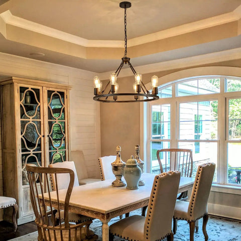 Dining room featuring Black Farmhouse Wagon Wheel Chandelier With 8-Light 23.6 Inch Vintage Industrial Round Pendant Ceiling Light Fixture For Kitchen Island Dining Room Living Room Bedroom Hallway Entryway Foyer With Adjustable Chain hanging above a table.