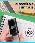 Quit The Daily Grind With This Rock Solid Self Inking Inspection Stamp Built For Fast Track Quality Approval And Seamless Record Keeping On Busy Office Floors Or Local Shop Workbenches, compact black stamp in hand on notebook.