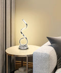 Modern Spiral LED Table Lamp With Dimmable Touch Control And USB Port 22W Reading Light for Bedroom on a round side table in a living room