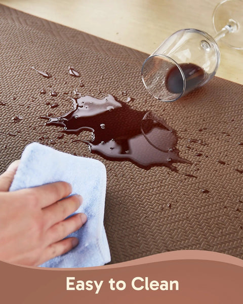 Anti Fatigue Kitchen Floor Mat 20 By 32 Inches Three Quarter Inch Thick Cushioned Ergonomic Standing Pad Waterproof Surface Non Slip Bottom For Home Office Sink Brown with a spill resistant surface being wiped clean.