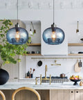 Stylish Hand Blown Glass Pendant Lights For Kitchen Island In Blue Marble Finish Modern Rustic Farmhouse Style With Brushed Nickel Hardware 8.7 Inch Diameter 2 Pack hanging over a kitchen island