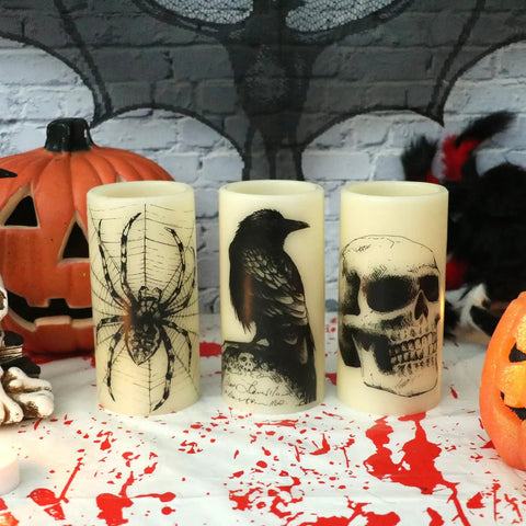 Halloween LED Flameless Candles 3 Pack With 6 Hour Timer Battery Operated 3 Inch Diameter By 6 Inch Height Spooky Decals Featuring Crow Raven Spider On Web And Skull Indoor Halloween Decor For A Chill Haunted Vibe, showing spider, crow, and skull designs on cream candles.