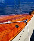 Boat with wooden deck on water featuring heavy duty nylon pulley guide set for boats and kayaks with rolling bearing visible.