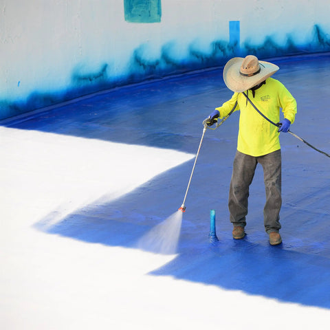 Worker applying Max Stretch Roof Coating White Elastomeric Sealant For Flat And Low Slope Roofs One Gallon on blue surface
