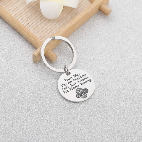 Trust Me I Am An Engineer Keychain With Gear Design on a wooden tray