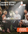 Rechargeable 12000mAh Camping Light With Adjustable Stand And 3 LED Heads illuminating an outdoor dinner scene at night.