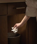 Battery Operated LED Puck Light For Under Cabinets And Shelves With Motion Sensor And Auto Shut Off After 20 Seconds 30 Lumen Bright White Cabinet Lighting No Fuss Easy Install illuminating under cabinet area as hand reaches for trash can.