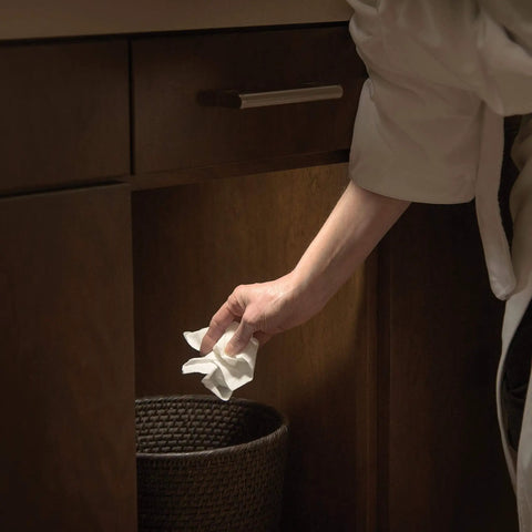Battery Operated LED Puck Light For Under Cabinets And Shelves With Motion Sensor And Auto Shut Off After 20 Seconds 30 Lumen Bright White Cabinet Lighting No Fuss Easy Install illuminating under cabinet area as hand reaches for trash can.
