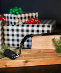 Pro Grade Heavy Duty High Pressure Rubber J Roller with Curved Handle on wooden board near gifts