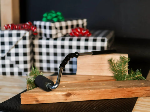 Pro Grade Heavy Duty High Pressure Rubber J Roller with Curved Handle on wooden board near gifts