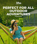 Person relaxing in a guacamole colored 40-Inch Wide Brazilian Style Hammock With Hand-Woven Rope Loops And Hanging Hardware Indoor Outdoor Cotton-Poly Blend 250 Lbs Capacity in a backyard.