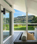 5 Inch Cylinder Outdoor LED Wall Sconce With 2 Lights Up And Down in black aluminum, mounted on porch wall with lake view