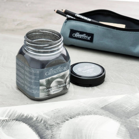 Open jar of Cretacolor graphite powder with lid, pouch, and drawing. Focus on smooth smudging and blending, water soluble option. Highly pigmented.