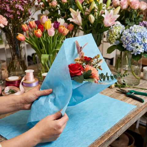 Florist wrapping bouquet with Waterproof Bouquet Wrapping Paper 266 Sheets With Easy Pullout Tissue For Flowers And Florist Arrangements.