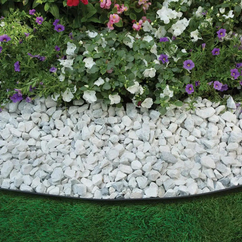 No Dig Landscape Edging Kit, 100 Ft Flexible Black Border With 32 Anchoring Spikes in a garden next to flowers and rocks