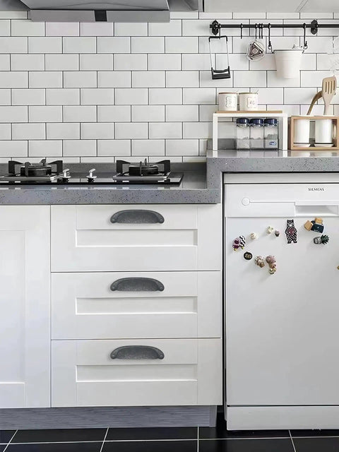 Solid As A Rock 10 Pack Rustic Cup Pulls In Matte Black Iron on kitchen drawers and white refrigerator.