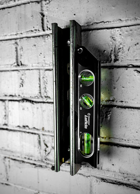 Lufkin Aluminum Billet Level With Large Main Vial, full aluminum body, shown on brick wall with magnets for strong hold
