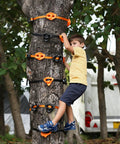 Child climbing on tree using 20 Ninja Tree Climbing Holds Kit With 6 Ratchet Straps For Outdoor Ninja Warrior Obstacle Course Training In Bright Orange And Black For Kid Safe Totally Fun Climbing Set.