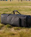 Rock Solid Drum Hardware Rolling Bag With Smooth Gliding Wheels And Extra Thick Padding For Snare Cymbal Stands And Kick Drum Pedals legit heavy duty music gear hauler in black resting on grass.