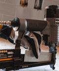 Worker holding a 3 In 1 Pneumatic Nail Gun That Rocks A 16 GA Finish Nailer 18 GA Brad Nailer And Stapler SL31 in a workshop