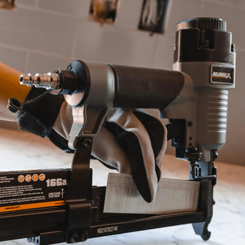 Worker holding a 3 In 1 Pneumatic Nail Gun That Rocks A 16 GA Finish Nailer 18 GA Brad Nailer And Stapler SL31 in a workshop