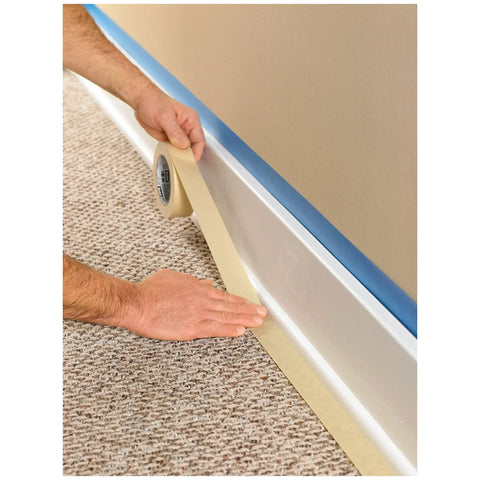 Person applying General Purpose Masking Tape Tan 0.70 Inch By 60 Yard Roll for labeling painting bundling on carpet edge