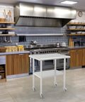 Stainless Steel Work Table With Undershelf And Casters, Flat Top Commercial Prep Table For Kitchen, Restaurant, And Garage, Heavy Duty, Scratch And Rust Resistant, Easy To Clean, NSF Certified, 30 Inch in a modern kitchen setting.