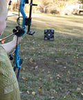 Child aiming a bow at Travel Pro Portable Layered Foam Archery Target With Welded Core Technology in a backyard