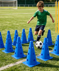 Boy dribbling soccer ball through blue cones on field using Backyard Agility Course Set With Low Hurdles And Cone Obstacles For Pups And All Breed Sizes An Epic Outdoor Training Kit For Fun Fitness And Coordination In The Yard Park Or Garden
