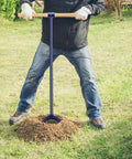 Person using 6 Inch By 46 Inch Heavy Duty Hand Auger Post Hole Digger With Hardwood T Handle Non Slip Grip in garden.