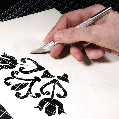 Pro Grade Hobby Knife Set With 1 Precision Craft Knife And 10 Ultra Sharp SK5 No 11 Blades For Paper Vinyl Leather Wood And Polymer Clay Projects Fatigue Free Control And Clean Detailed Cuts being used for paper cutting design.
