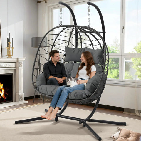 Two Person Foldable Hanging Egg Chair With Stand For Indoor Outdoor Use Wicker Porch Swing Chair Heavy Duty Rattan Hammock Loveseat With Cushions For Bedroom Garden Balcony Patio 650 Lbs Cozy Vibes indoors with couple and cat.