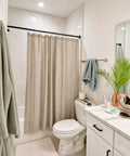Bathroom setting with Heavy Duty Tension Curtain Rod No Drill Quick Install for Patio Shower and Windows, black, installed over bathtub.