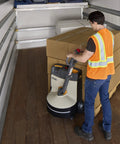 Man using Compact Crown Wj 50 Electric Pallet Jack With Lithium Battery for hauling stacked boxes in a truck.