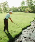 Golfer retrieving ball from water with Jawz Golf Ball Retriever With 14 Foot Length And 18 Foot Reach, Ultra Compact Design