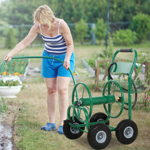 Woman using Heavy Duty Garden Hose Reel Cart Holds Up To 300 Feet Of Hose, Tough Four Wheel System on lawn, green cart visible